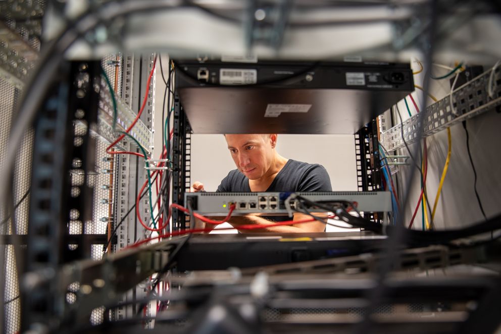 Mitarbeiter der IT führt Wartungsarbeiten an einem Server-Rack durch
