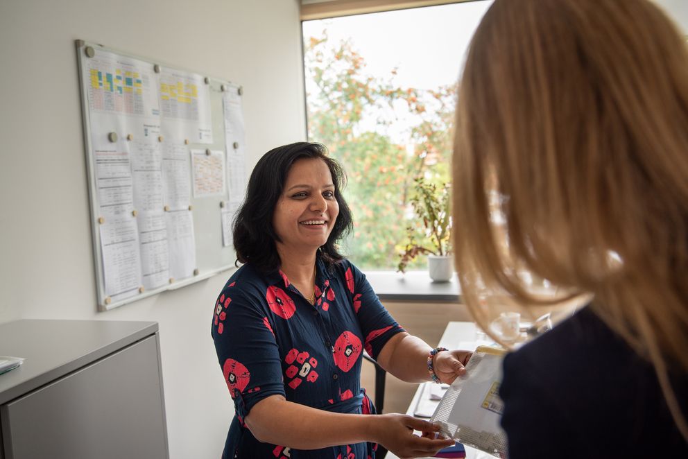 Mitarbeiterin der Gemeinde Gröbenzell übergibt ihrer Kollegin eine Tasche mit Schlüsseln